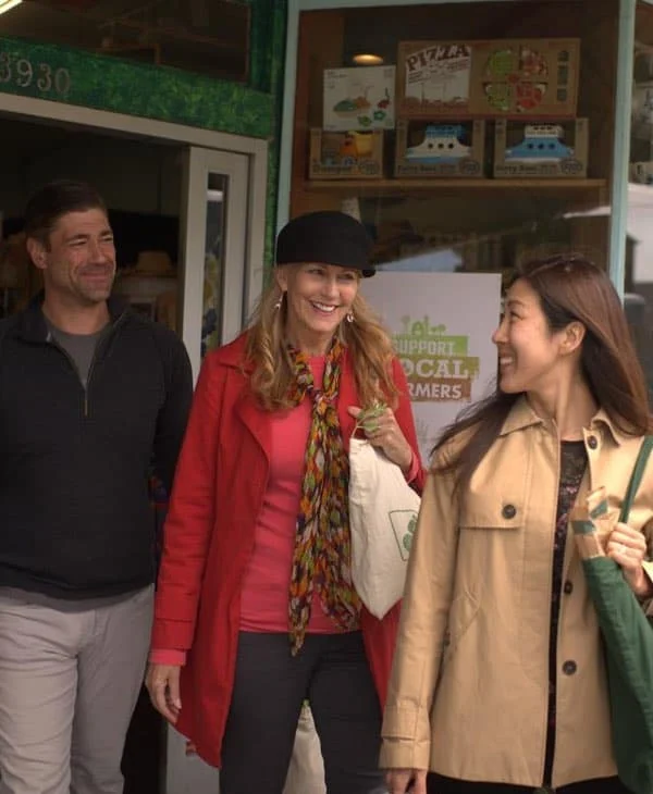 Three people leaving a food co-op smiling