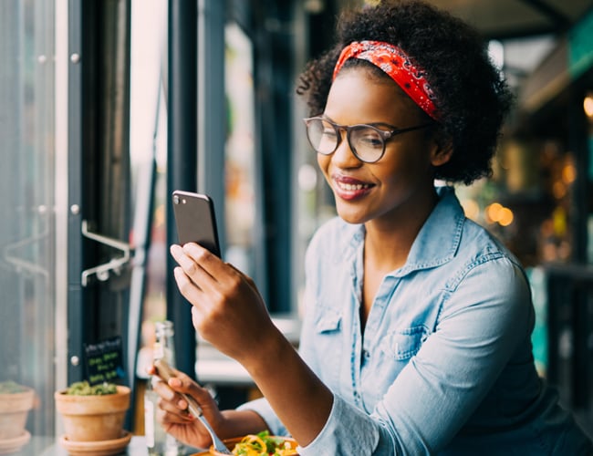 woman checking her mobile banking at a cafe